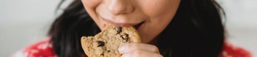 lady munching on a chocolate chip cookie